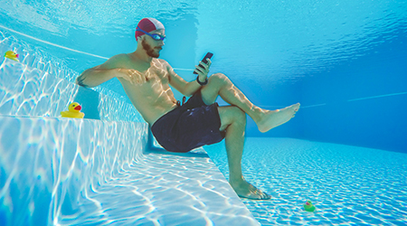 Man using social media on smartphone in the pool