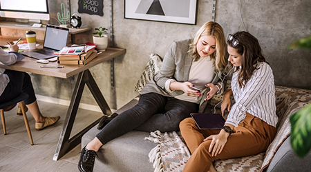 Friends looking at a phone on the couch