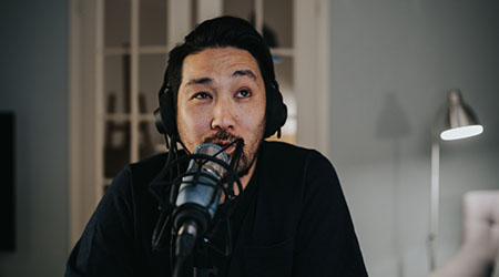 Podcaster speaking into professional condenser microphone