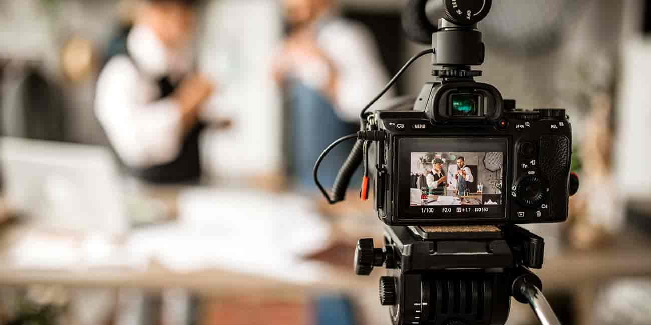 A close up of camera as it livestreams two people in the far distance