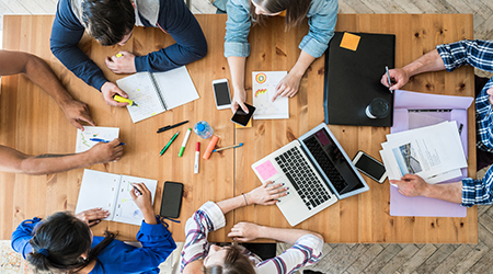 Marketers discuss digital strategy around a wooden table