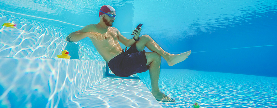 Man using social media on smartphone in the pool