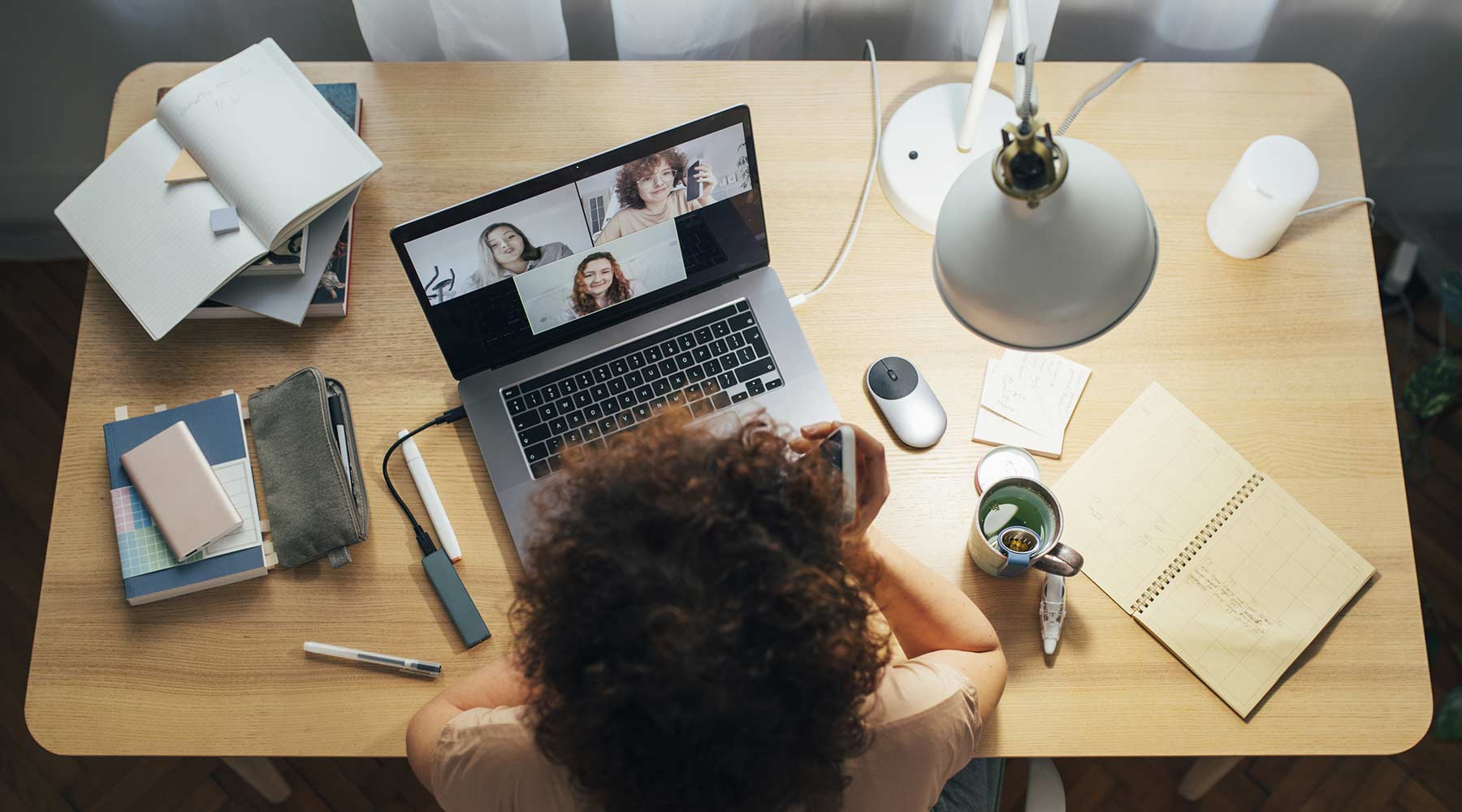 A person holds a video conference on their desk