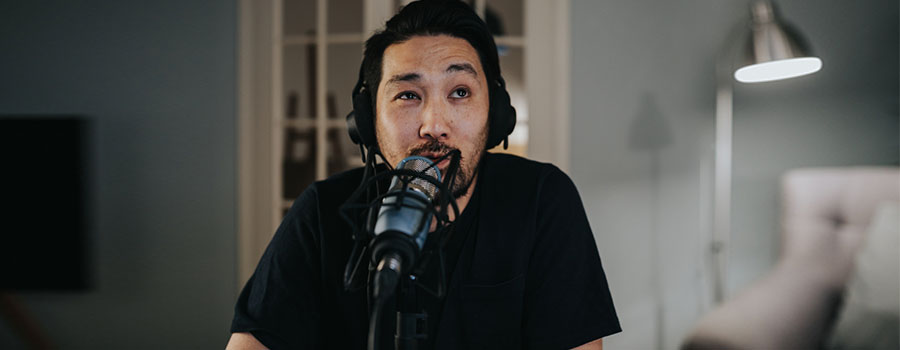 Podcaster speaking into professional condenser microphone