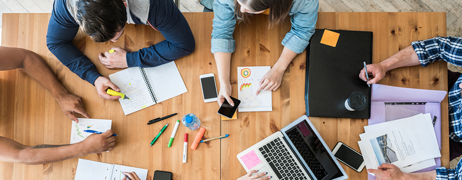 Marketers discussing digital strategy around a wooden table